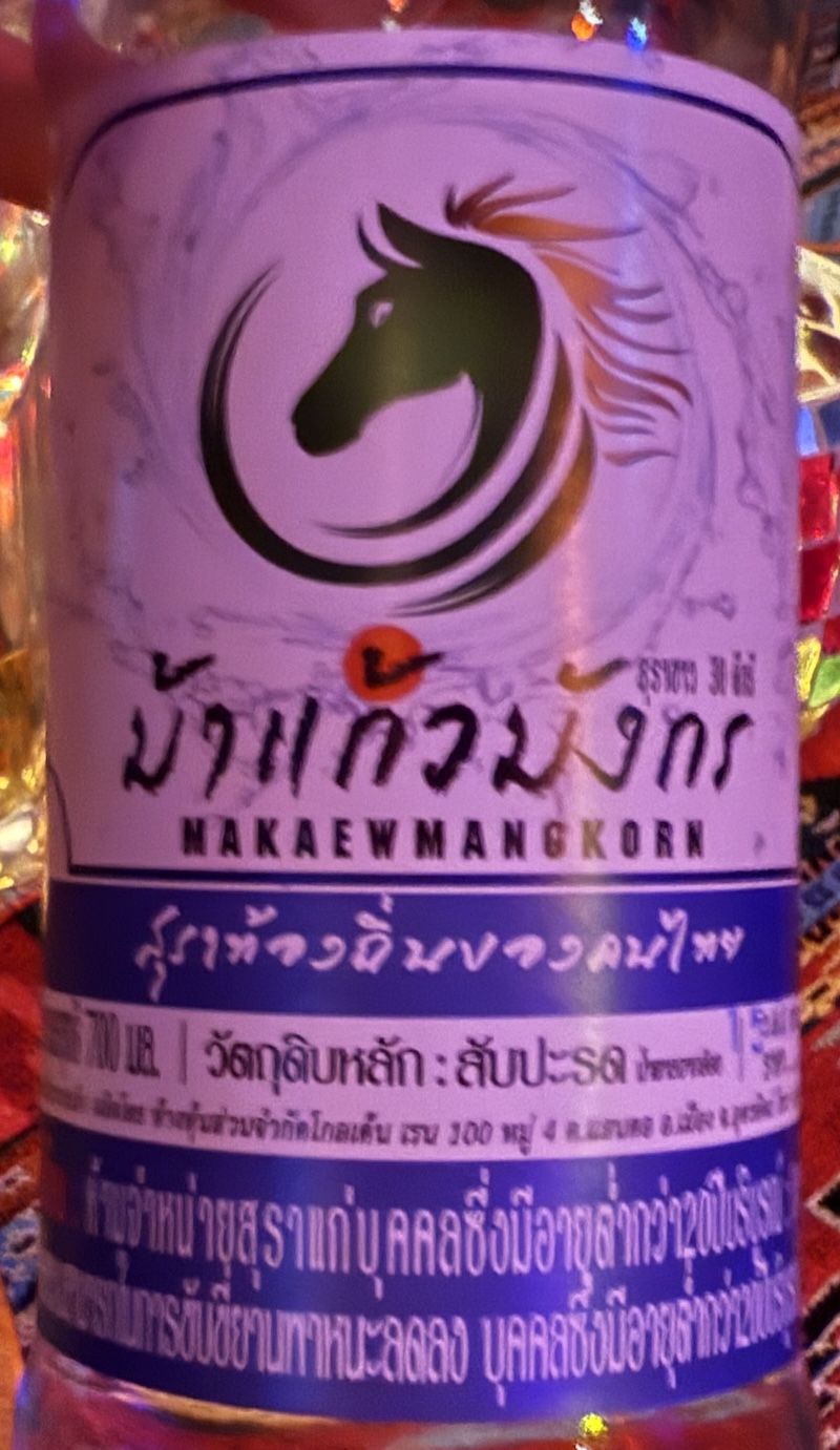 Bottle of spirit with a horse's head and a some writing in Thai script