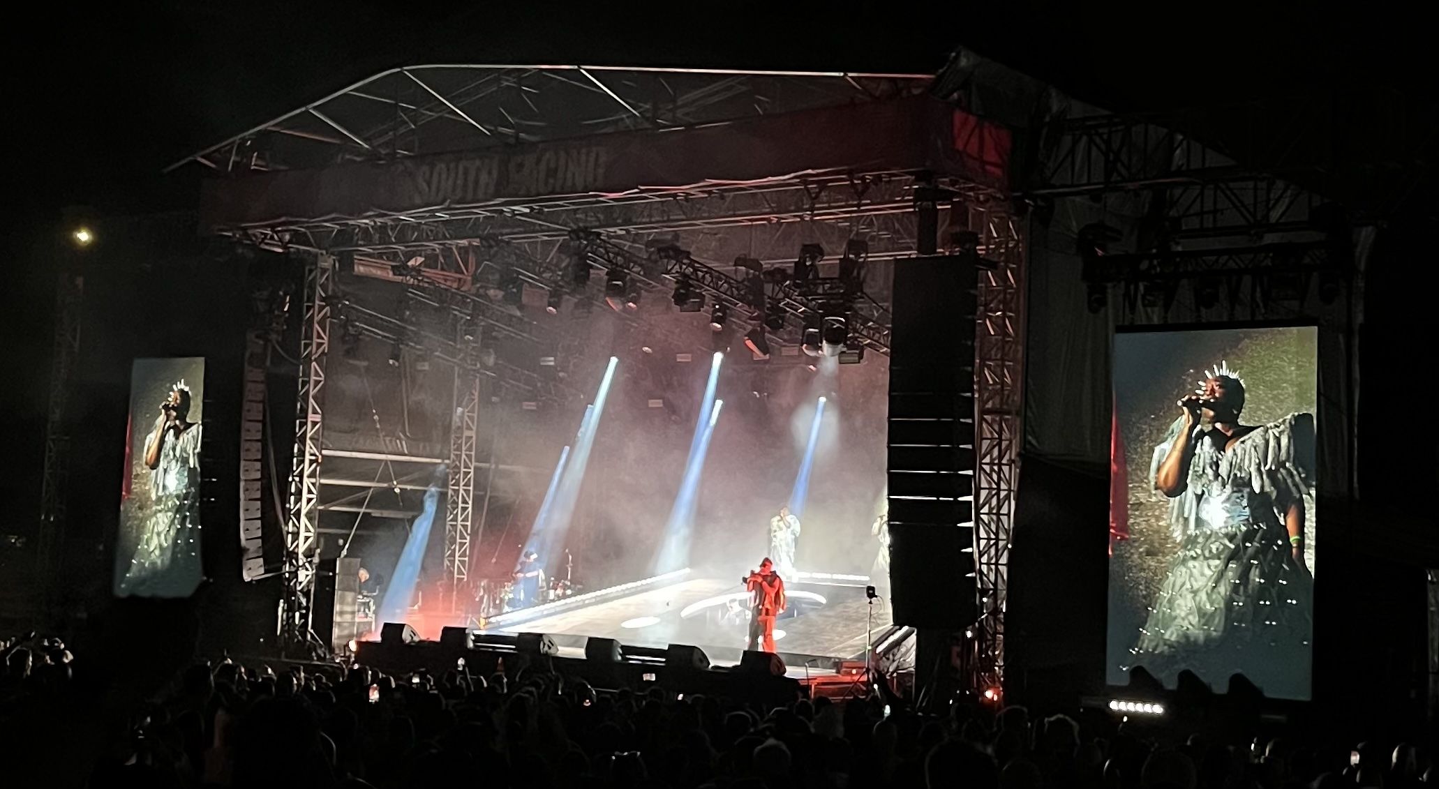 Basement Jaxx live on stage, the screen show one of the singers with a silver costume and metal mohican